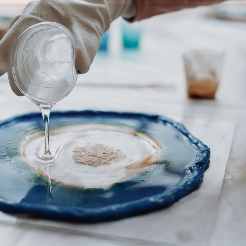 Clear epoxy resin being poured during epoxy flooring preparation in Tampa, FL.