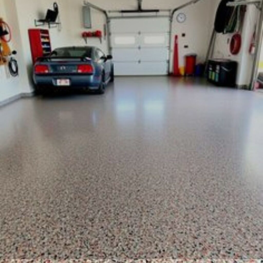 Garage epoxy flooring in Venice, FL, featuring a durable decorative flake finish and parked vehicle.